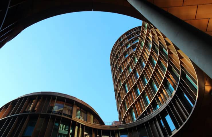 Innovative architectural design featuring a sleek, curved skyscraper with glass exterior.