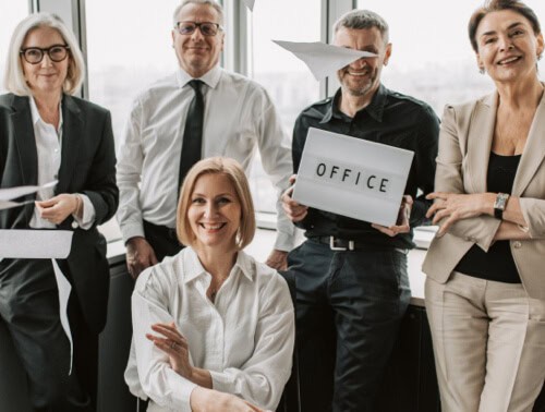 Team of professionals celebrating success in a modern office environment.