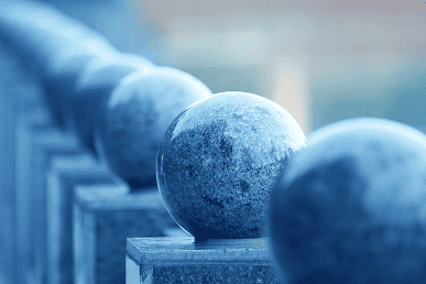 Modern blue stone spheres on a railing, representing stability and innovation.