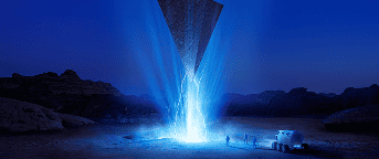 Modern water fountain illuminated at night with vibrant blue lights.